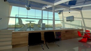 A modern interior with a glass ceiling, a wooden counter, and two black chairs. - Le Ville (Ouro Preto)