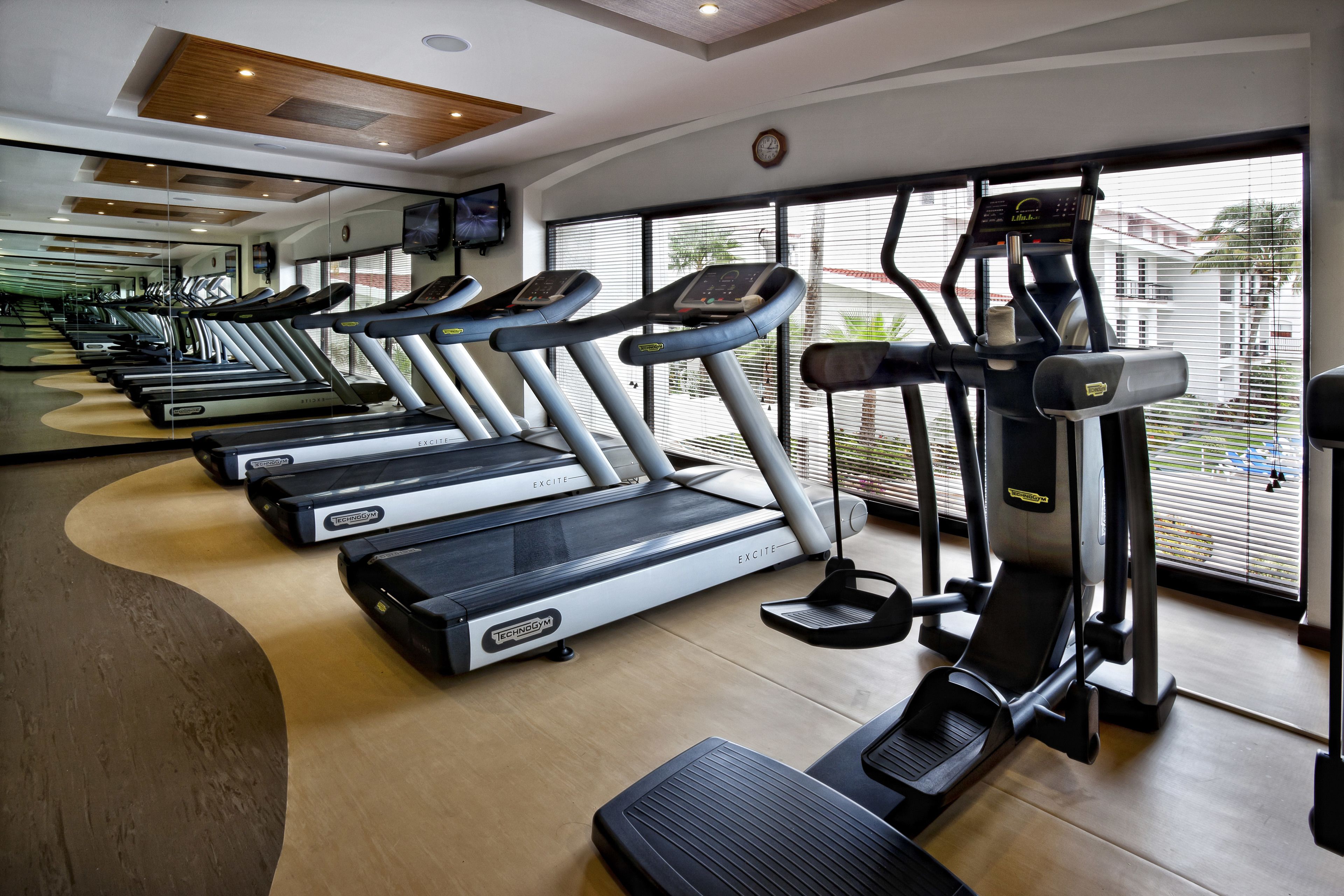 A gym with multiple treadmills, a stationary bike, and a rowing machine.
