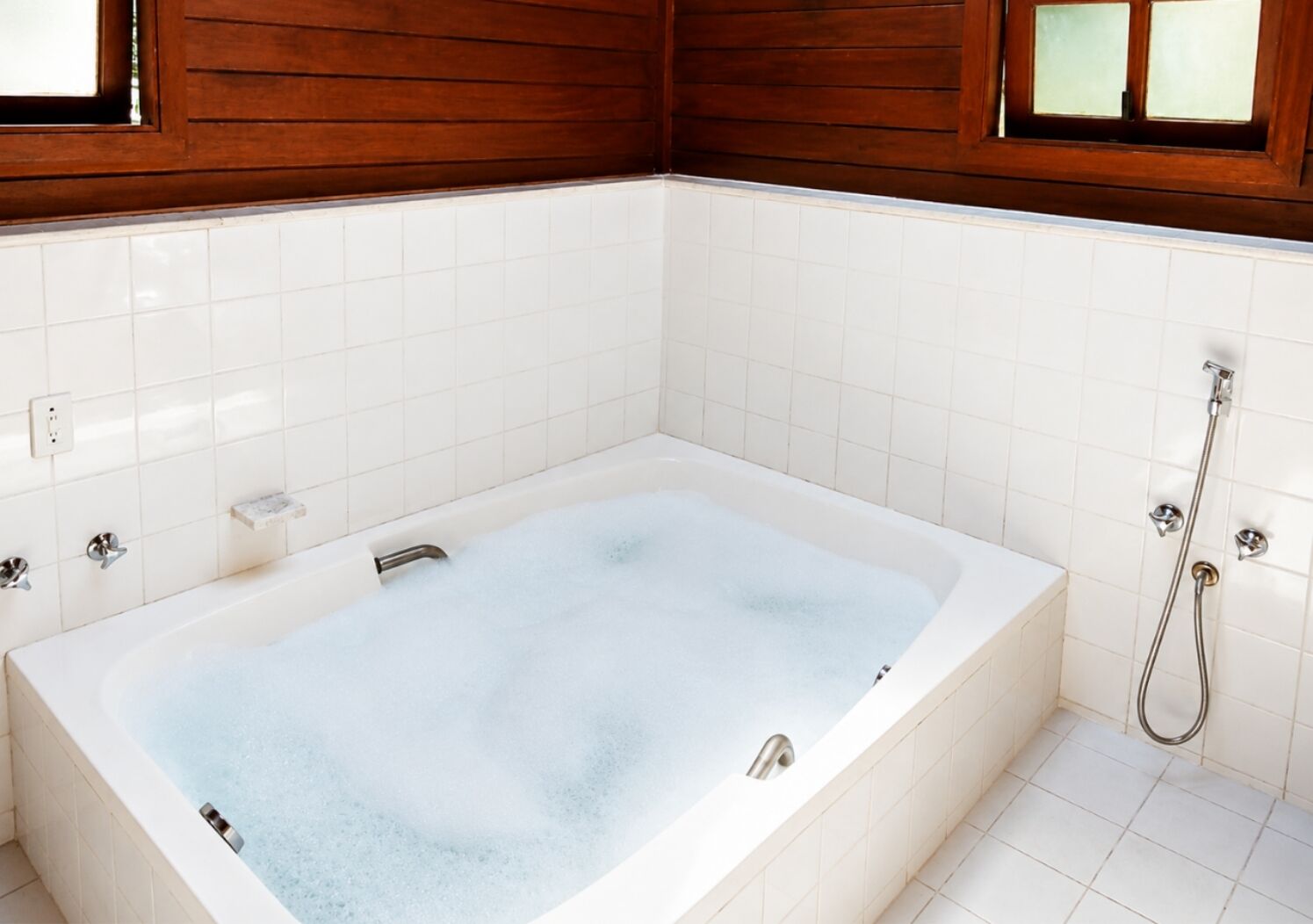 Ein Badezimmer mit Badewanne, Dusche und Fenster.