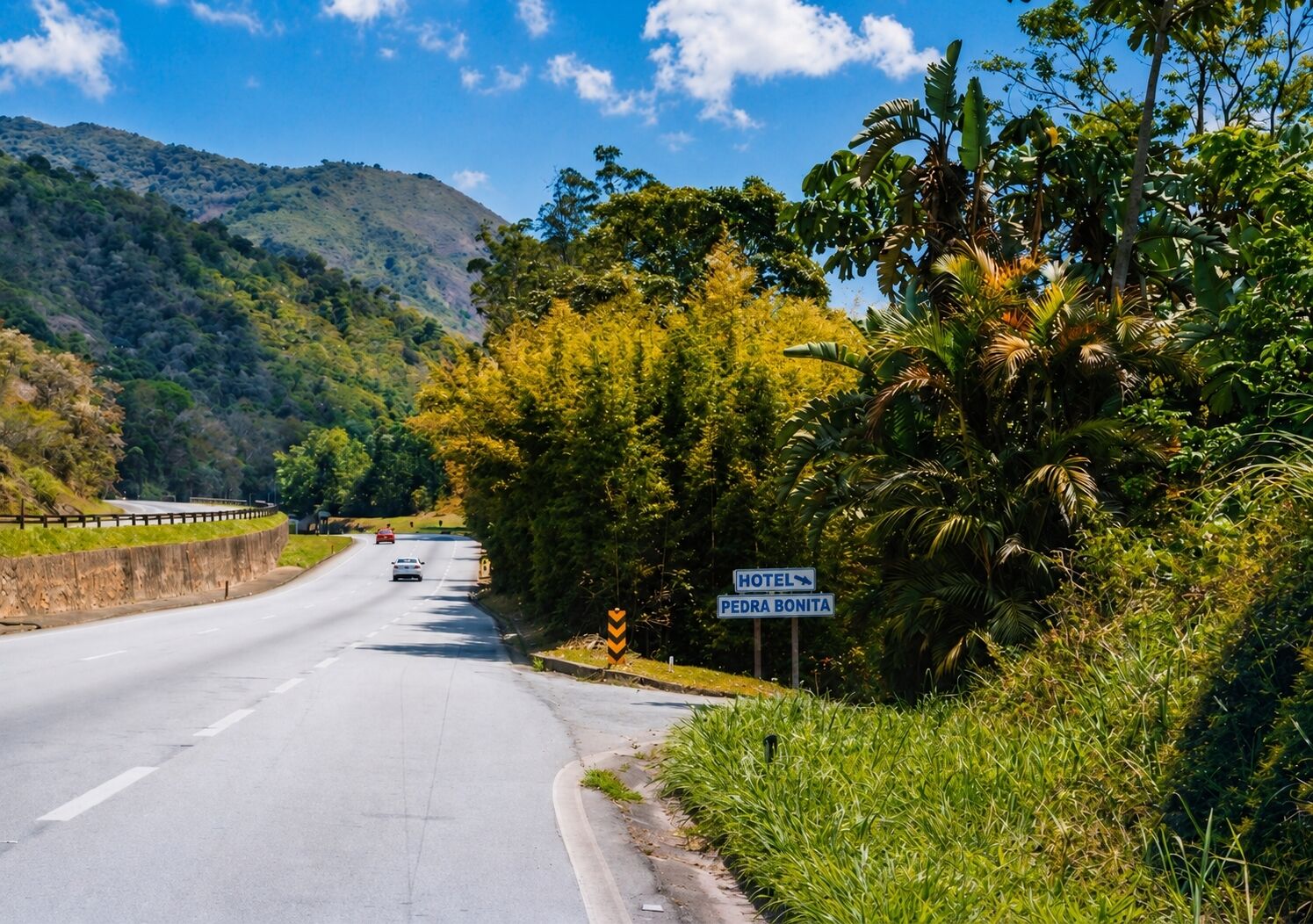 Una carretera con un cartel de hotel que indica 'HOTEL PEDRA BONITA' a la derecha.