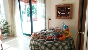 Un comedor con una mesa dispuesta para una comida, mostrando una variedad de platos y bebidas.