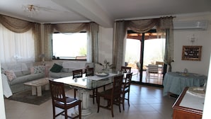 Un amplio salón con una mesa de comedor, sillas, un sofá y una mesa de centro.