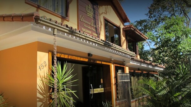 A hotel with a balcony, a sign indicating it is a Princess Hotel, and a contact number. - Pousada Princesa Isabel Dom Pedro (Petrópolis)