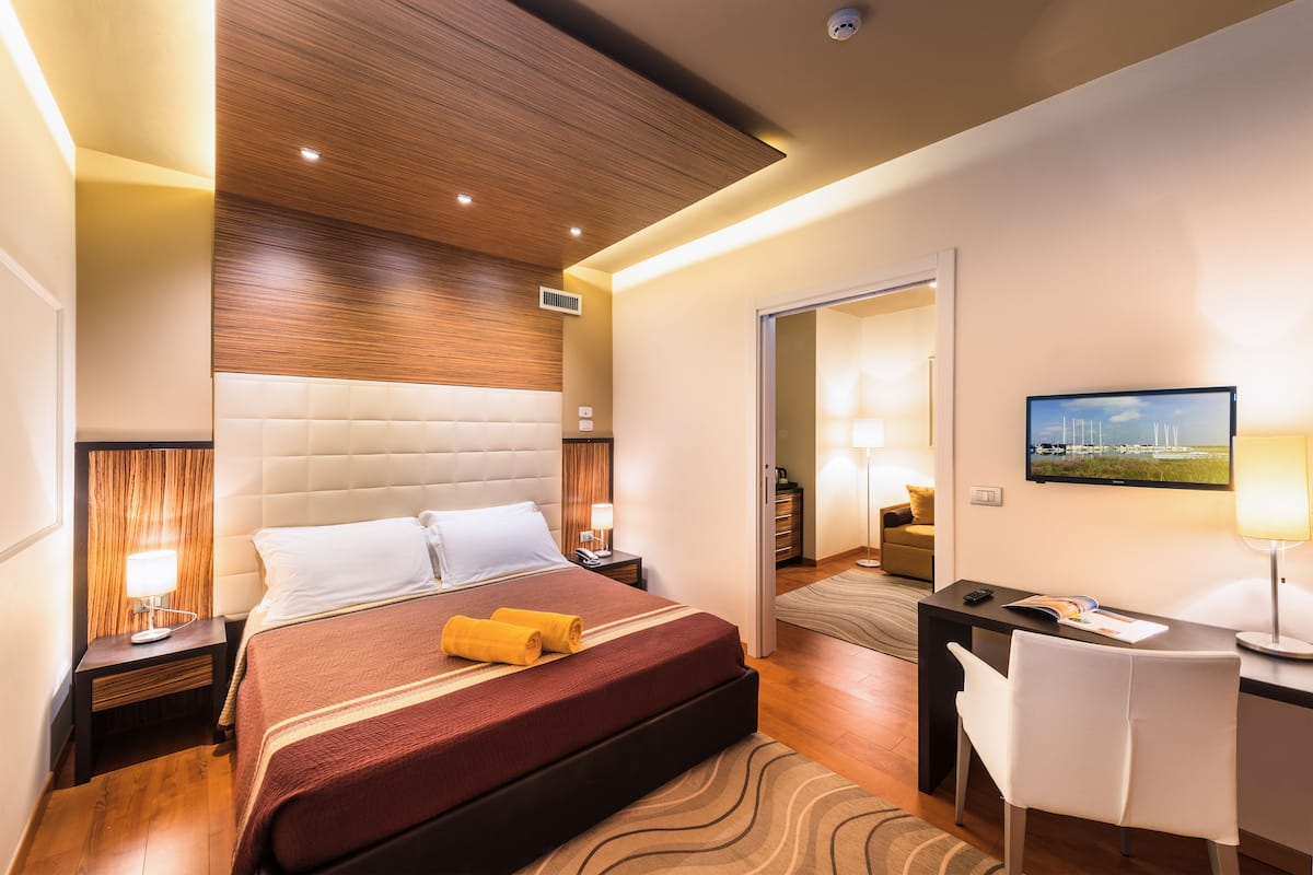 Een moderne hotelkamer met een groot bed, een bureau en een televisie.