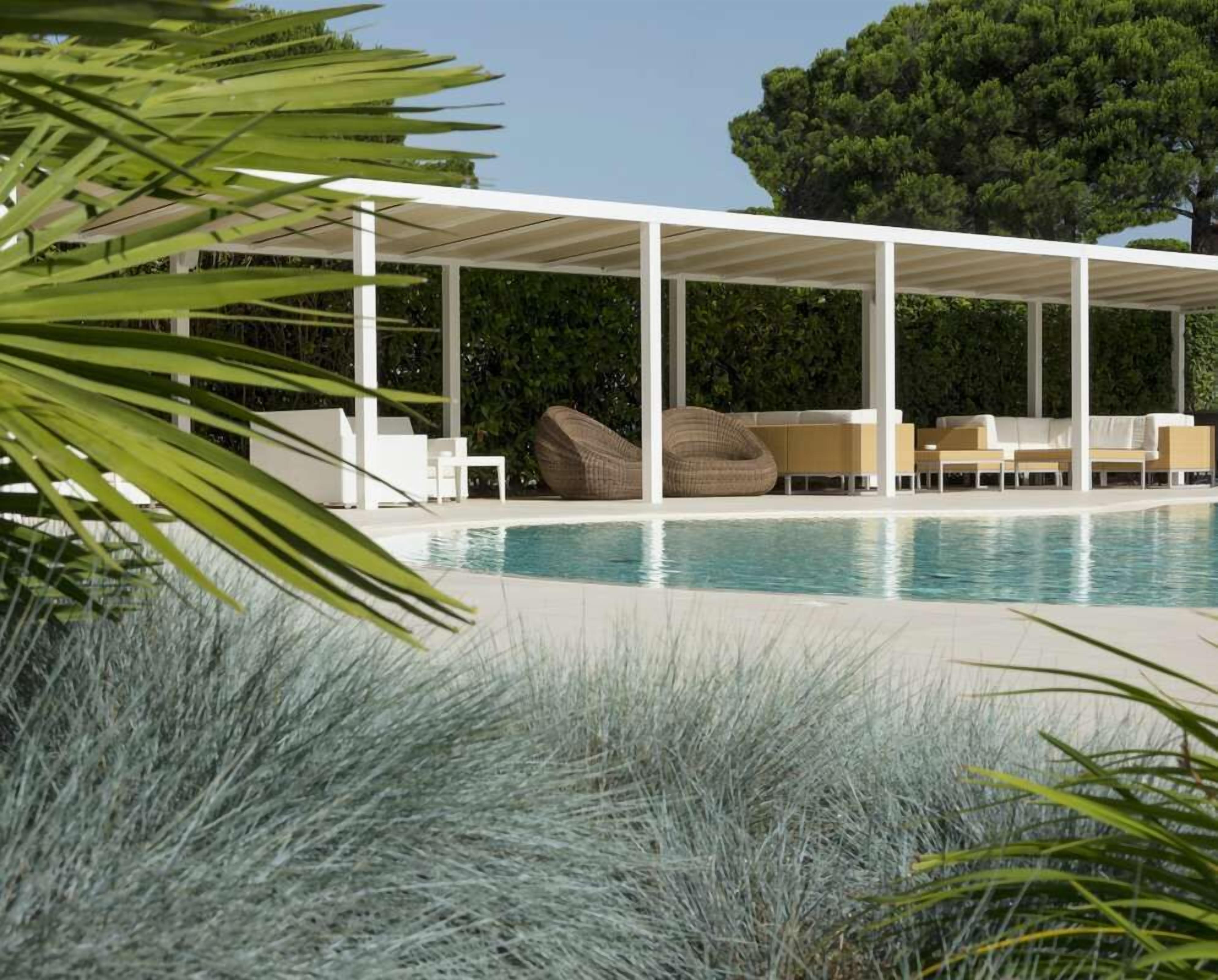 Alberca al aire libre, sombrillas en la alberca y camastros 