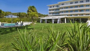 A hotel with a pool, outdoor seating, and a well-maintained lawn. - Hotel San Marco (San Michele al Tagliamento)