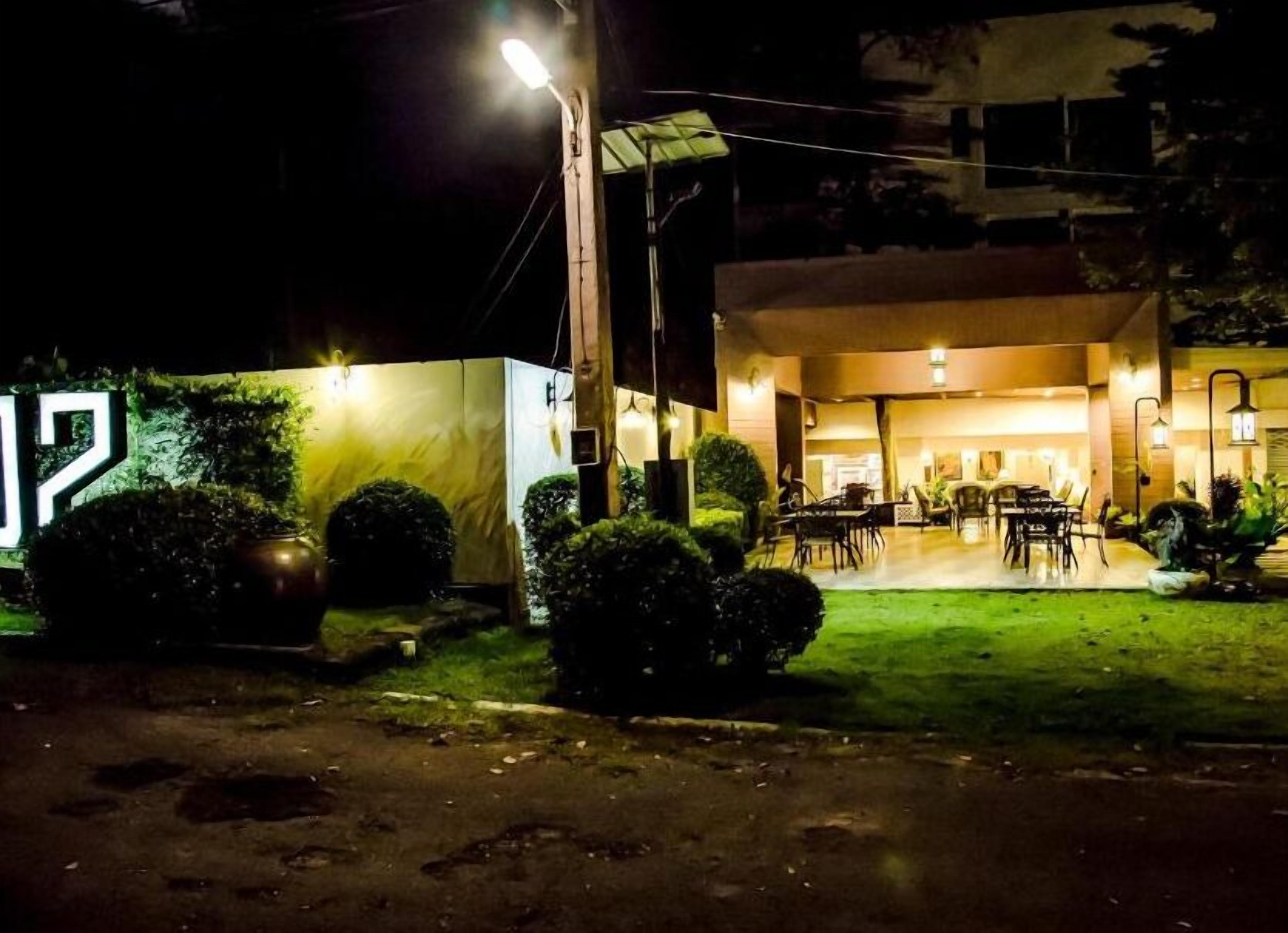 A building with a covered outdoor seating area and a well-lit entrance.
