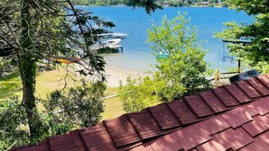 Une vue sur le lac, avec des bateaux amarrés, une terrasse en bois et un ciel dégagé.