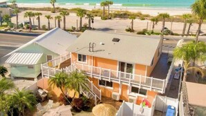 Un hotel frente a la playa con balcón, mobiliario exterior y vista al océano.