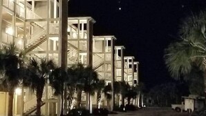 A multi-story hotel with a modern architectural design, featuring balconies and a central staircase.