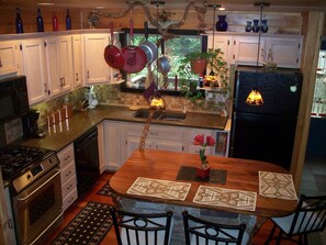 A kitchen with white cabinets, a wooden table, and a refrigerator.