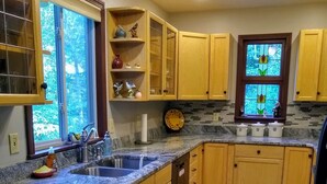 A kitchen with wooden cabinets, a granite countertop, a sink, and a window with a view of trees. - Mountain VIEW! -  Private-Romantic -Secluded -WiFi (Ellijay)