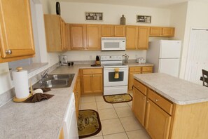 Fully equipped kitchen with microwave, stove, sink, and refrigerator.