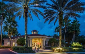 Classic Mediterranean architecture with a central entrance flanked by palm trees.