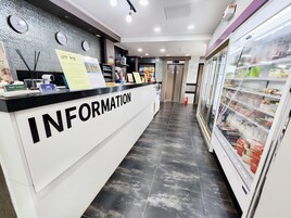 Un área de recepción con un mostrador blanco identificado con