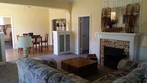 Ein Wohnzimmer mit Kamin, einem Essbereich und einer Küche im Hintergrund.