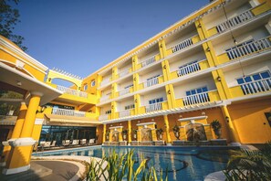 A multi-story hotel with balconies, a swimming pool, and outdoor seating areas. - Sunlight Guest Hotel Coron (Coron)