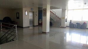 A spacious lobby with a staircase, seating area, and a visible elevator. - Asia Novo Boutique Hotel - Sorsogon (Sorsogon City)