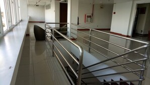 A spacious hallway with a metal railing, a trash bin, and a door in the background. - Asia Novo Boutique Hotel - Sorsogon (Sorsogon City)