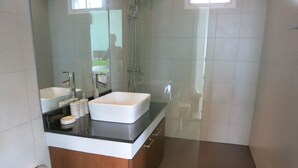 A modern bathroom with a large sink, a mirror, and a shower. - Residence Harmonie (Rawai)