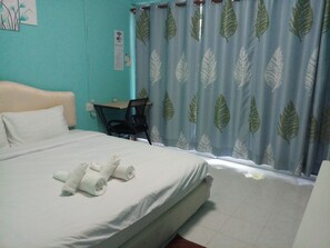 A hotel room with a bed, a desk, and a chair. There is a sign on the wall indicating Wi-Fi availability. - Kata S.T. House (Karon)
