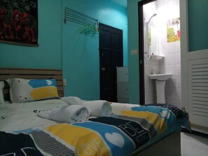 A bedroom with a bed, a door, a bathroom with a sink, and a shower. - Kata S.T. House (Karon)