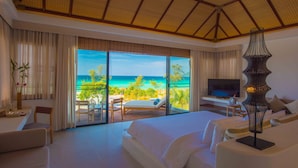 A spacious bedroom with a large bed, a balcony with a view of the ocean, a television, and a modern lamp. - The Royal Sands Koh Rong (Koh Rong)