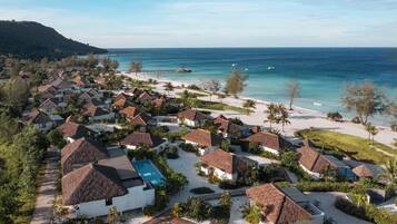 A resort with thatched-roof cottages, a swimming pool, and a beach.