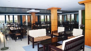 A spacious indoor area with multiple tables and chairs arranged for dining or socializing. - Tea Heaven Resort (Sreemangal)