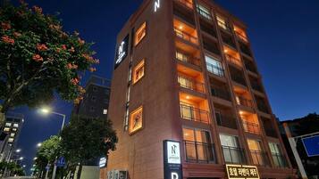 A multi-story hotel with a prominent 'N' sign, balconies, and a 'P' parking sign.