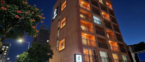 A multi-story hotel with a prominent 'N' sign, balconies, and a 'P' parking sign.