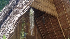 Uma cabana com telhado de palha e um banco de madeira no interior.
