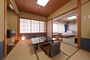 A traditional Japanese-style room with tatami flooring, a low table, and a futon bed. - Subaruyado Yoshino (Tokushima)
