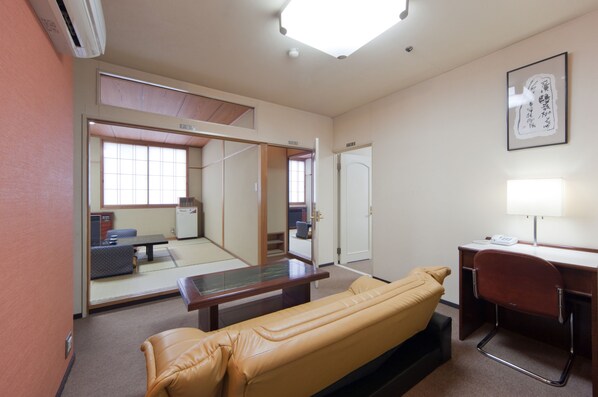 A room with a bed, a desk, a chair, a table, and a mirror. - Subaruyado Yoshino (Tokushima)