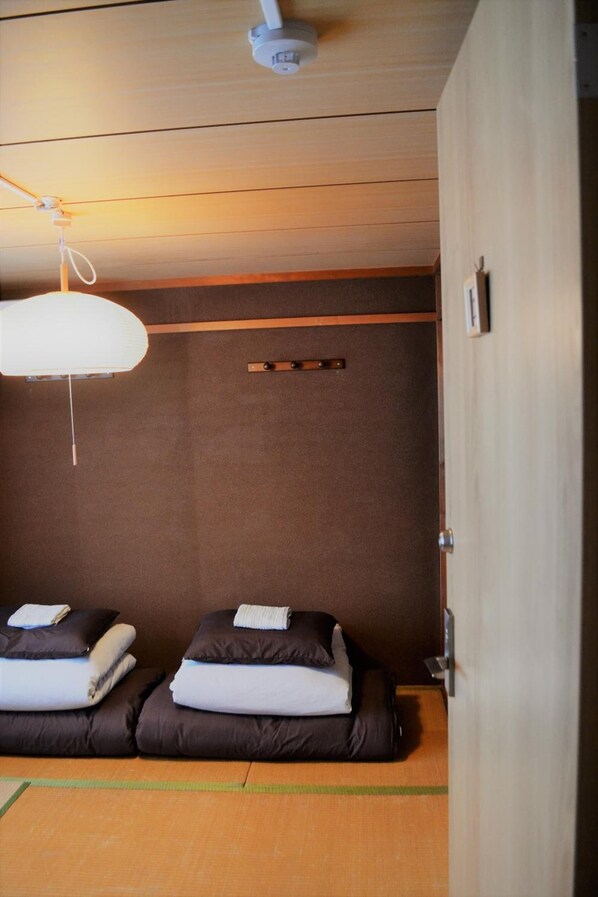 A room with two beds, a ceiling fan, and a wooden floor. - Peace House Abeno - Hostel (Osaka)