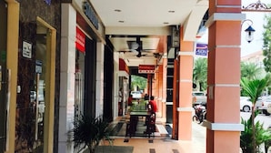 A corridor with shops on either side, a seating area with tables and chairs, and a ceiling with recessed lighting. - 91 Street Boutique Inn (Miri)