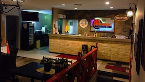 A reception area with a stone counter, a clock, and a sign for '91 Street Boutique Inn'. - 91 Street Boutique Inn (Miri)