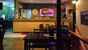A restaurant with a stone wall, a neon sign, and a clock. - 91 Street Boutique Inn (Miri)