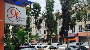 A street view with a sign for 'A Street Boutique Inn' and parked cars. - 91 Street Boutique Inn (Miri)