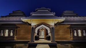 A traditional building with a central entrance, two side wings, and a symmetrical design.
