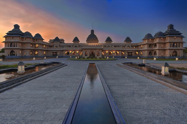 A large, multi-tiered building with a central water feature and multiple lanterns.