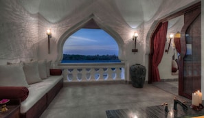 A cozy balcony with a view, a seating area with cushions, and a decorative vase.