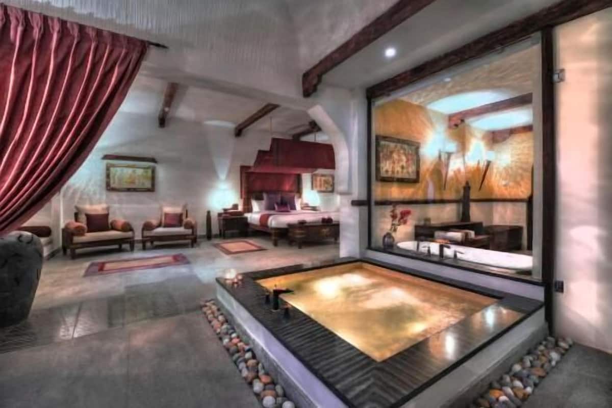 A spa room with a hot tub, seating area, and artwork on the walls.