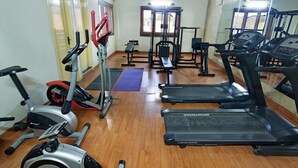 A gym with treadmills, elliptical machines, and weightlifting equipment. - HM Suites & Studios Bangalore (Bengaluru)