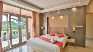 Une chambre d’hôtel moderne avec un grand lit, un balcon offrant une belle vue et un plafond bien éclairé.