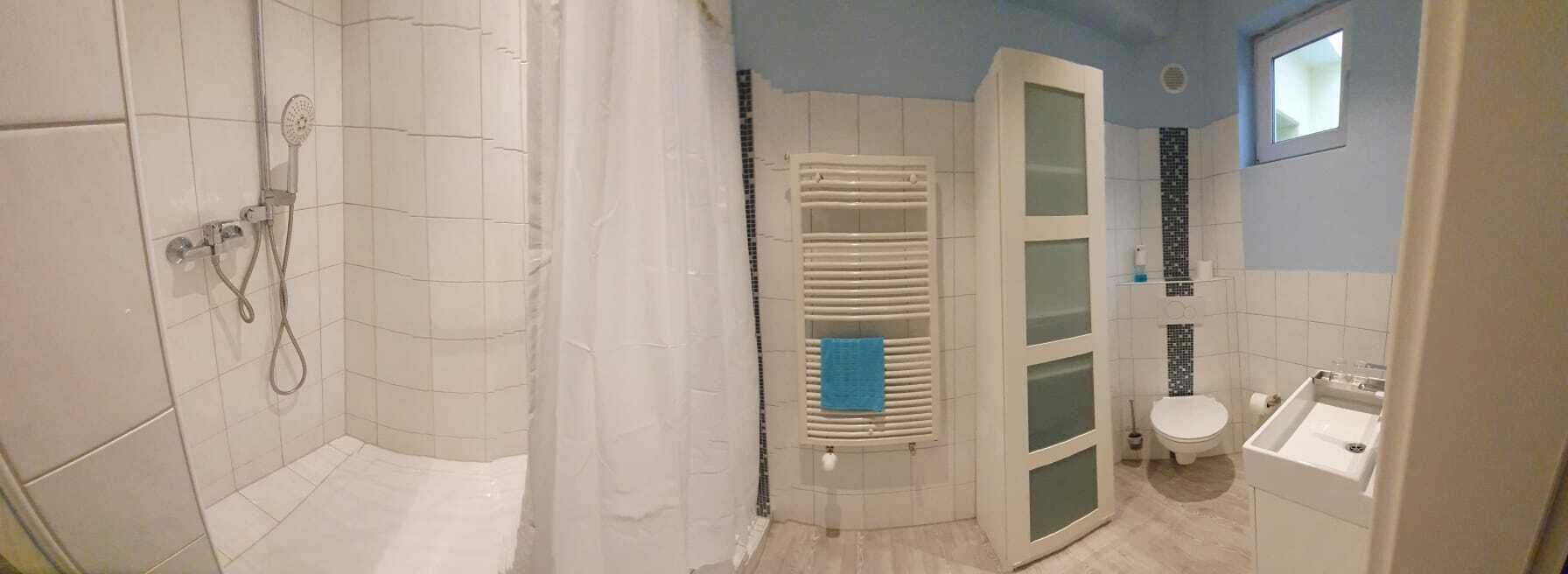 A bathroom with a shower, toilet, and sink.