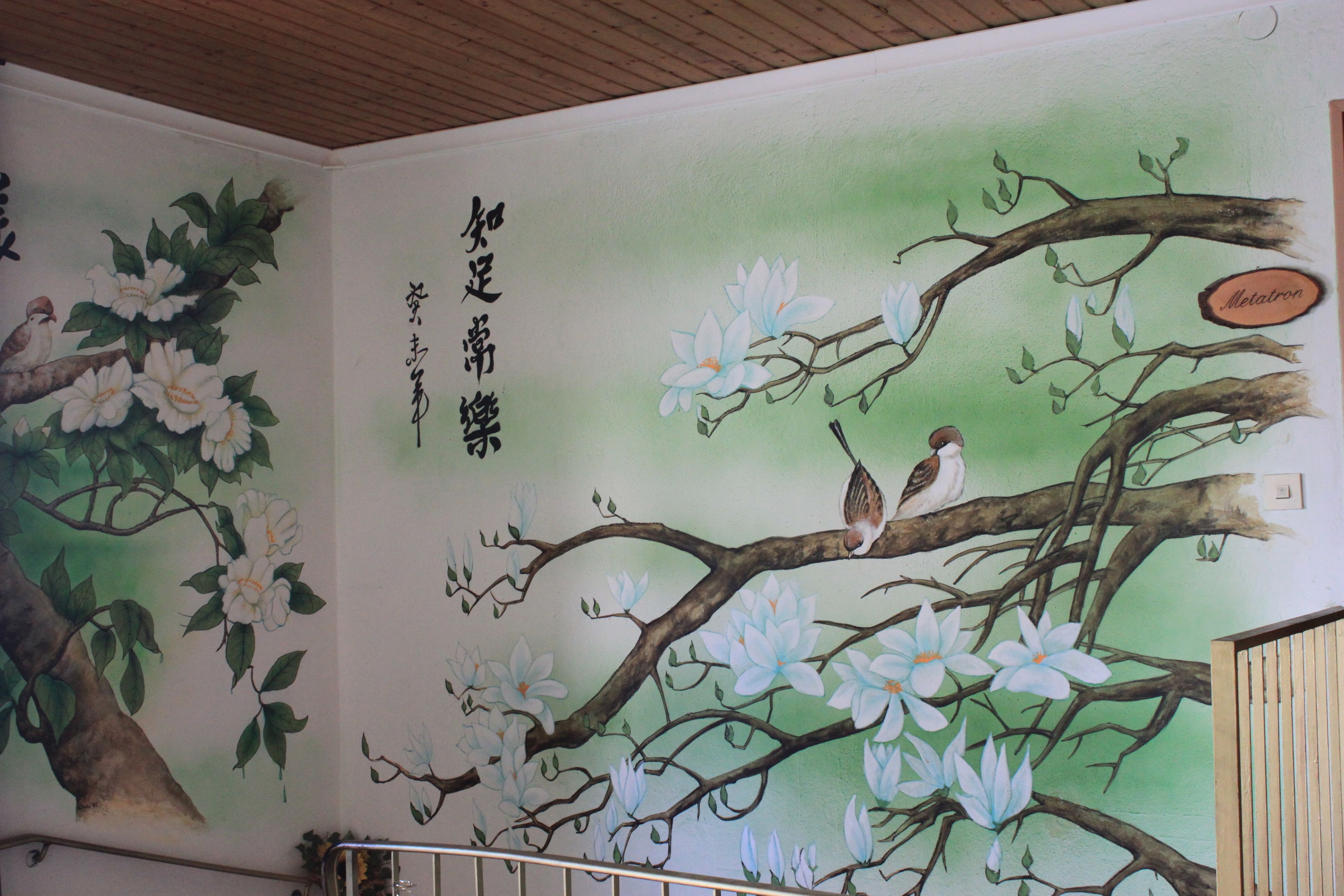 Um mural com pássaros e flores em uma parede.