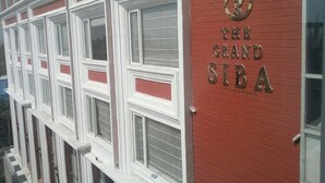 Um edifício vermelho com uma placa que diz "The Grand SIBA".