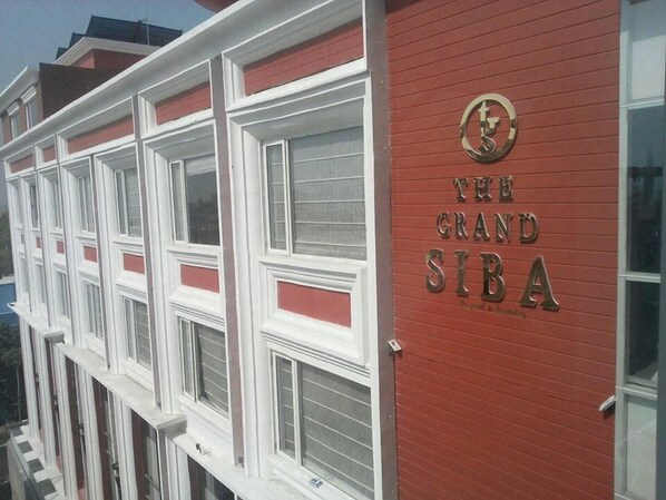A red building with a sign that reads "The Grand SIBA."
