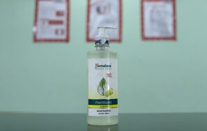 A bottle of Himalaya PureHands hand sanitizer on a table. - Hotel Turista (Bengaluru)